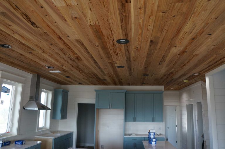 Pot lights in kitchen with unique wood plank ceiling.